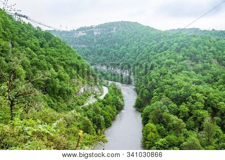 A Gorge In The Mountains With A Suspension Bridge Over It. Skybridge Suspension Bridge Over A Precip