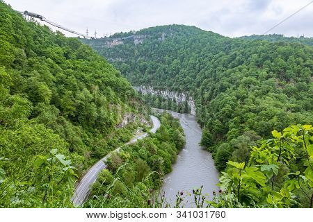 A Gorge In The Mountains With A Suspension Bridge Over It. Skybridge Suspension Bridge Over A Precip