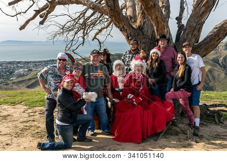 Santa And Mrs Claus Posed On Hilltop Two Trees With Board And Sponsors During First Annual Hike With