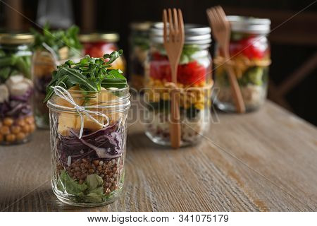 Glass Jar With Healthy Meal On Wooden Table