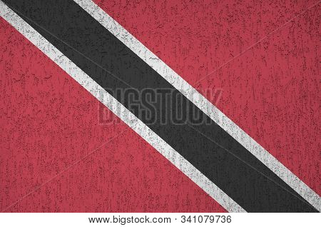 Trinidad And Tobago Flag Depicted In Bright Paint Colors On Old Relief Plastering Wall. Textured Ban