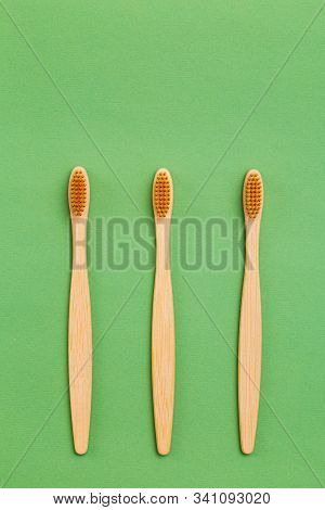 Wooden Toothbrush On Gren Background. Reusable. Minimalist Concept. Vertical Photo