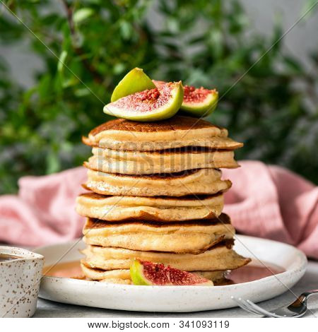 Stack Of Delicious Fluffy Pancakes Topped With Fresh Figs And Maple Syrup. Square Orientation. Sweet