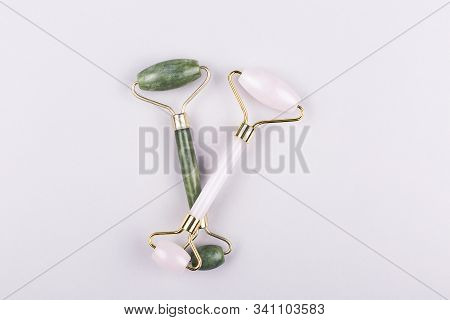 Two Trendy Jade Rollers Pink And Green On Blue Background. Flat Lay, Top View.