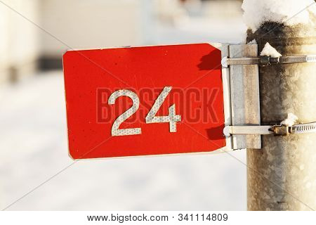 Red Sign With The Number Twenty Four In White With Winter Background