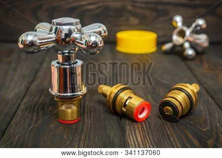 Cruciform Hot And Cold Water Main Switch Of Spare Parts On Black Wooden Boards