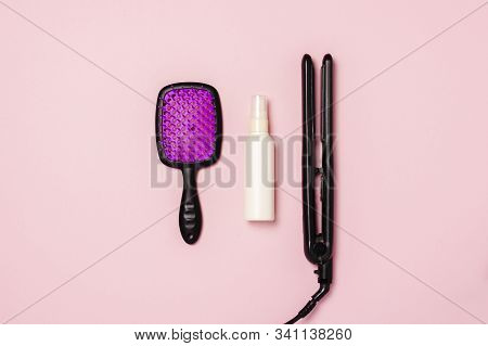 Hair Straightener, Comb And Hair Care Product On A Pink Background. Concept Of Hair Care, Hairstyle,