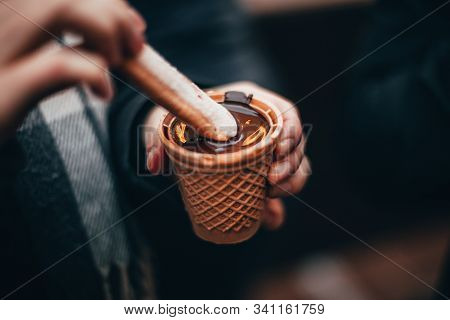 Woman Hands Eating Liquid Chocolate On The Chocolate Market Chocolart In Tübingen, Germany With Chri
