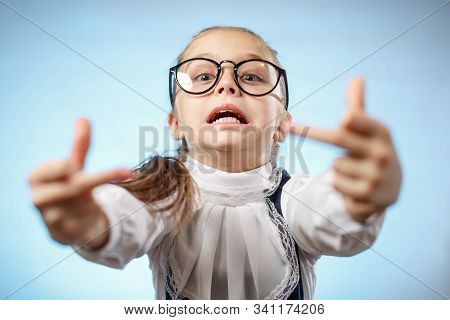 School Girl In Glasses Showing Middle Finger. An Insulting Gesture. A Bratty Child