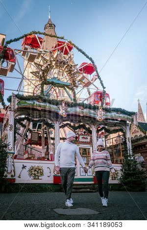 Young Couple Visit The Christmas Market In Cologne Germany During A City Trip, Men And Woman At Chri
