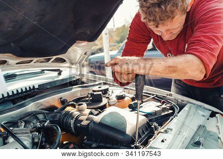 The Concept Of Disability Of People And Their Adaptation To Life. A Blond Disabled Man Repairs A Car
