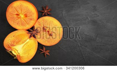 Delicious Slices Of Fresh Persimmon Fruit On A Black Background. Copy Space, Top View. Ingredients A