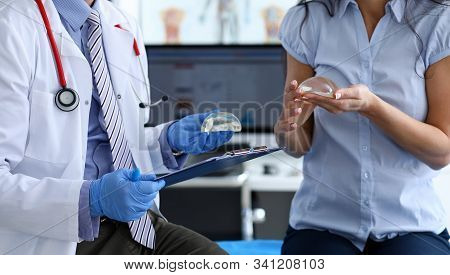 Male Doctor Hand In Blue Protective Gloves Hold With Female Patirnt New Fashion Silicone Breast Impl