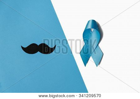 Light Blue Ribbon With Mustache On White And Blue Background. Prostate Cancer Awareness, Movember Me