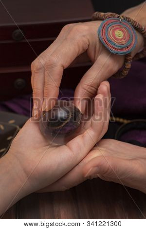 Woman Fortuneteller Puts A Ball Of Fate In Her Hand, A Magic Ball Of Predictions. The Concept Of Pre