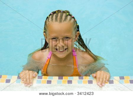 Ung flicka leenden vid poolen
