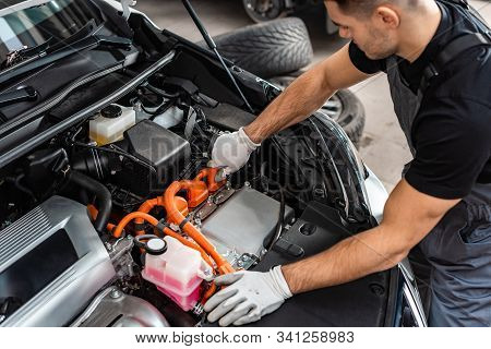 Young Mechanic Inspecting Car Engine Orange Compartment
