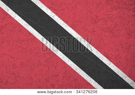 Trinidad And Tobago Flag Depicted In Bright Paint Colors On Old Relief Plastering Wall. Textured Ban