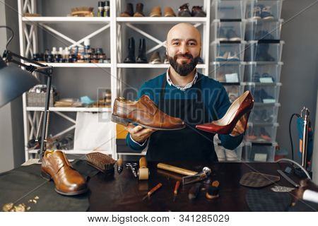 Bootmaker shows repaired shoes, footwear repair
