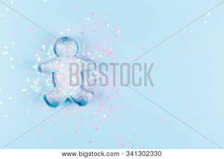 Flatlay With Gingerman Cookie Cutter And Snowflake Sprinkles On Blue Background. Holiday, Christmas 
