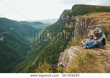 Cambara Do Sul, Brazil, July 17, 2019. People On Steep Rocky Cliffs In Fortaleza Canyon With Fog Com