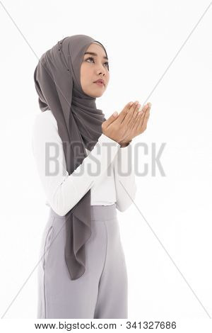 Young Adult Muslim Woman girl making Duas for Muslim god blessing prayer. Studio shot of woman isolated on white background