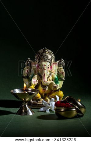 Hindu God Ganesha. Ganesha Idol. A Colorful Statue Of Ganesha Idol On Dark Background. Space For Tex
