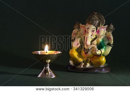 Hindu God Ganesha. Ganesha Idol. A Colorful Statue Of Ganesha Idol On Dark Background. Space For Tex