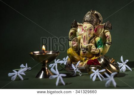 Hindu God Ganesha. Ganesha Idol. A Colorful Statue Of Ganesha Idol On Dark Background. Space For Tex