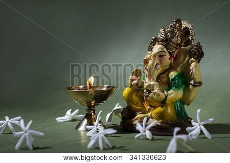 Hindu God Ganesha. Ganesha Idol. A Colorful Statue Of Ganesha Idol On Dark Background. Space For Tex