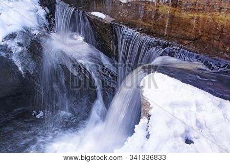 Blurred Waterfalls Flowing Down Through Enders State Forest In Granby Connecticut On A Sunny Winter 