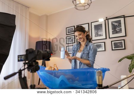 Female Vloger Recording Video About Newborn Baby Bathing As Part Of Online Prenatal Classes; Female 