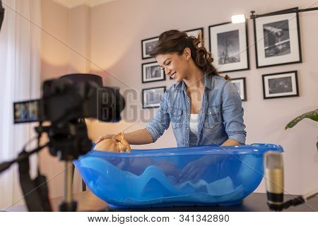 Female Vloger Recording Video About Newborn Baby Bathing As Part Of Online Prenatal Classes; Female 