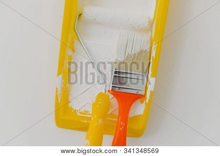Top View Of Paintroller And Paintbrush In Tray Over White Background. Refurbishment, Repairing And D