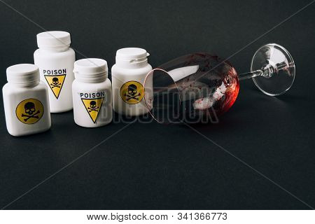 Wine Glass With Blood And Jars With Poison Sign Isolated On Black
