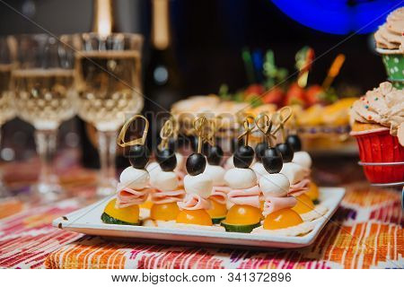 The Appetizer Of Vegetables And Ham Is Skewered And Laid On A White, Square Plate, Ready To Be Serve