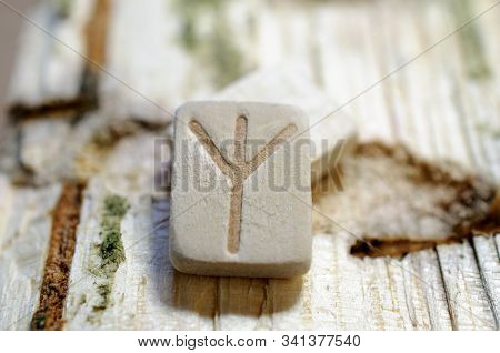 Wooden Rune Algiz Close-up On A Wooden Background. Soft Focus