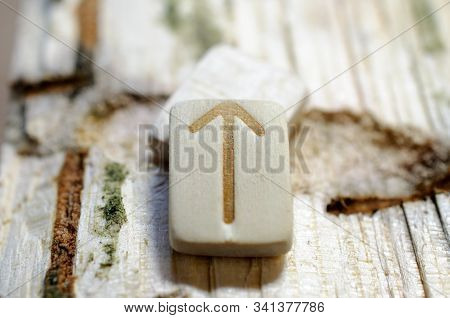 Wooden Rune Teiwaz Close-up On A Wooden Background. Soft Focus