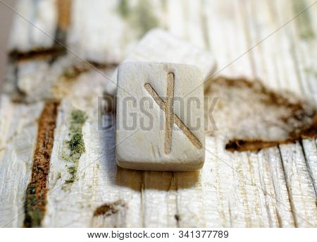 Wooden Rune Nauthiz Close-up On A Wooden Background. Soft Focus