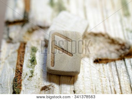 Wooden Rune Ansuz Close-up On A Wooden Background. Soft Focus