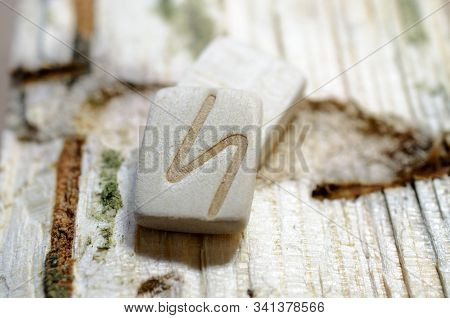 Wooden Rune Sowelu Close-up On A Wooden Background. Soft Focus