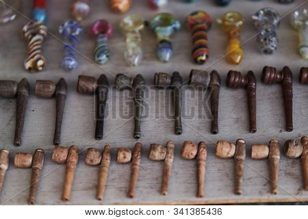 Different Pipes Smoking Tobacco On A Wooden Background. Top View.