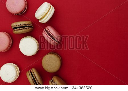 Macarons Cakes. Abstract Food Photo Background With Delicious Macaroons Over Red Background. Flat La