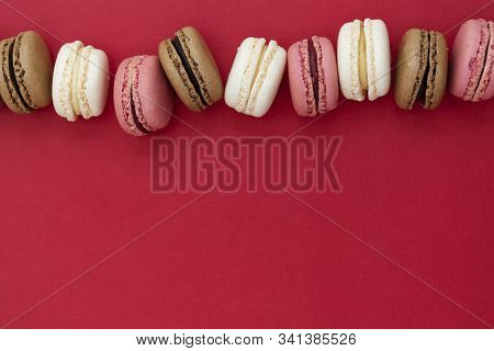 Macarons Cakes. Abstract Food Photo Background With Delicious Macaroons Over Red Background. Flat La