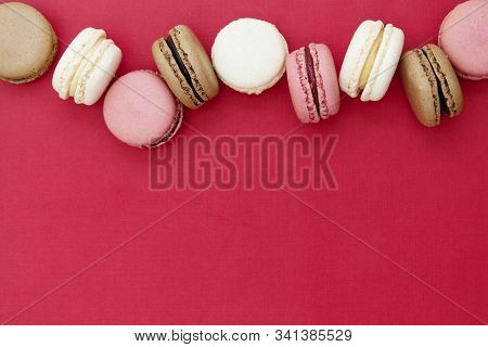 Macarons Cakes. Abstract Christmas Food Photo Background With Delicious Macaroons Over Red Backgroun