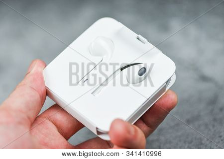 White Wireless Bluetooth Earphones Or Headphones Smartphone Earphones In Plastic Storage Case Isolat