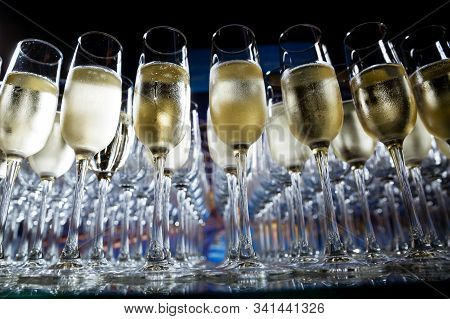 Many Champagne Glasses Stand On A Glass Table
