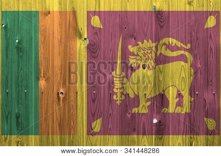 Sri Lanka Flag Depicted In Bright Paint Colors On Old Wooden Wall. Textured Banner On Rough Backgrou