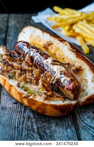Hot Dog With Caramelized Onion, Cheddar And Gruyere Cheese Sauce On Wooden Surface With Potatoes.