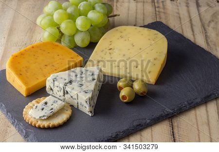Cheese Board With Three Cheeses, Gouda With Pimento, Gouda With Cumin Seeds And Roquefort Blue Chees